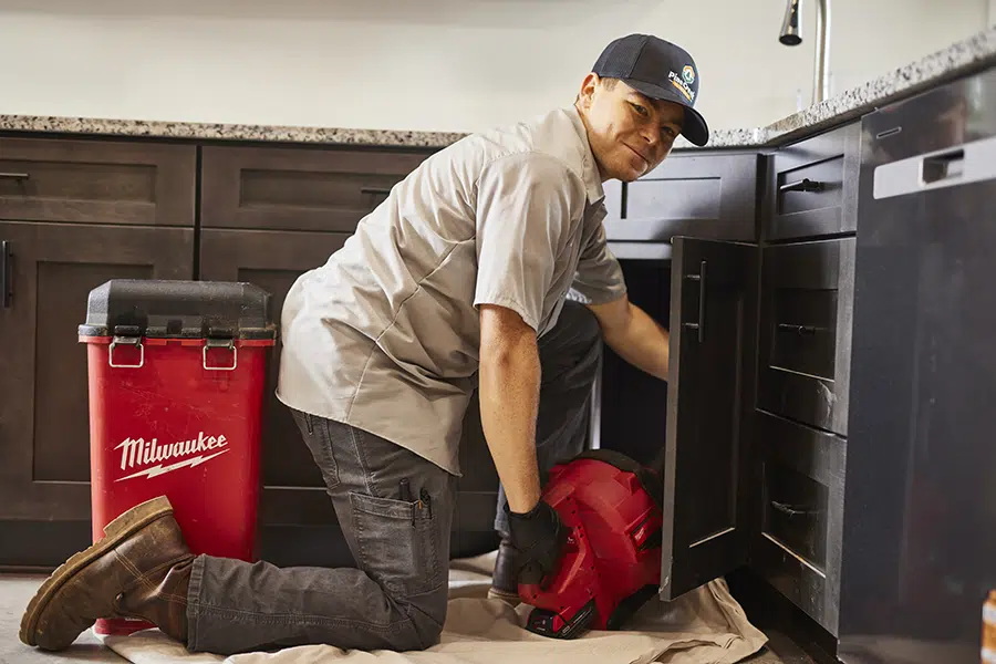Pine Creek plumber working under kitchen sink