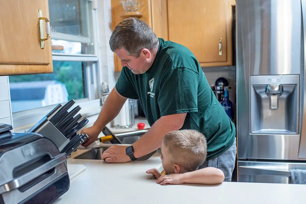 Pine Creek Plumbing technician working on kitchen sink in residential home in Wexford.
