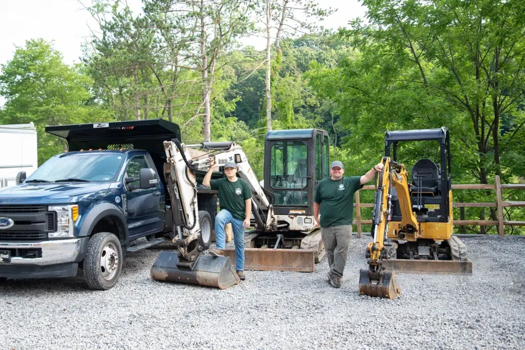 Pine Creek Plumbing technicians standing in front of excavators in Wexford.