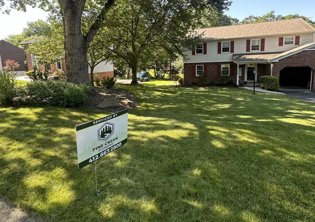 Pine Creek Plumbing yard sign in residential yard in Wexford.